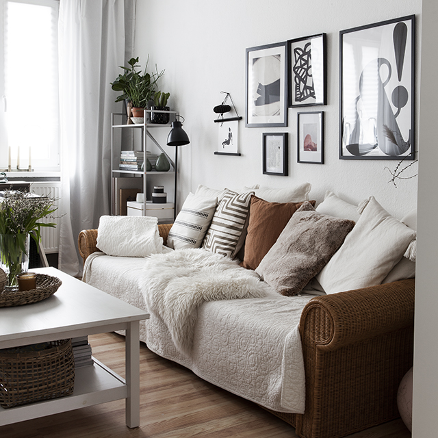 Wohnzimmer mit Rattan Couch und Bilderwand
