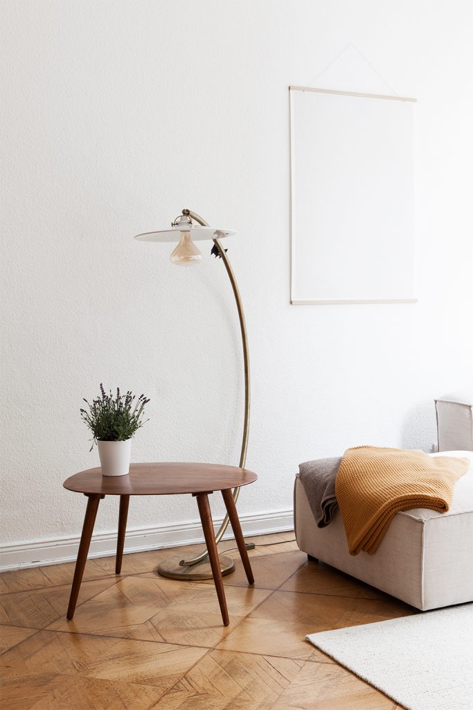 Design Klassiker Stehlampe mit Beistelltisch mit Kuscheldecken auf dem Sofa