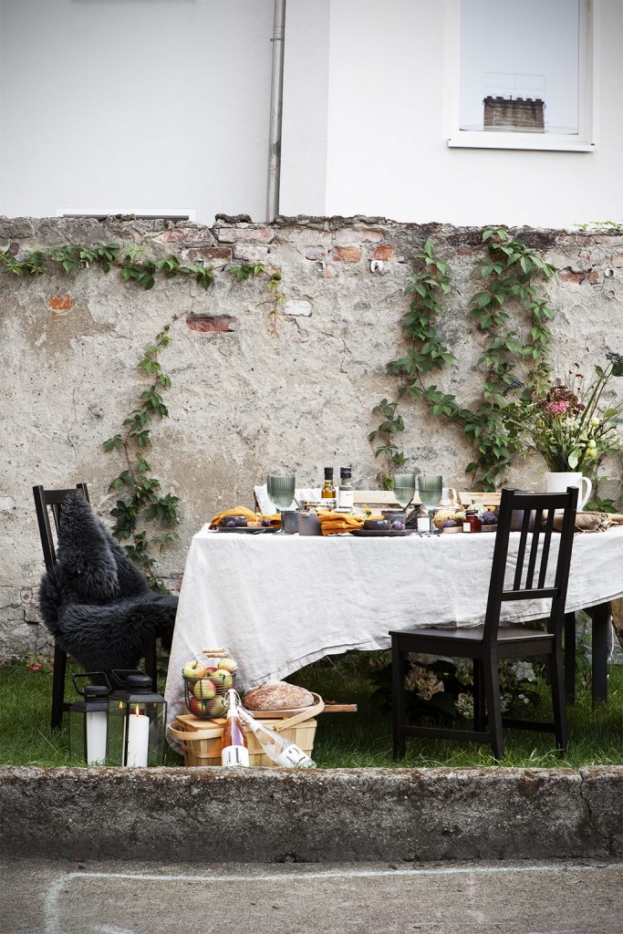 Herbstlich gedeckte Tischtafel mit Picknickkorb und Laternen