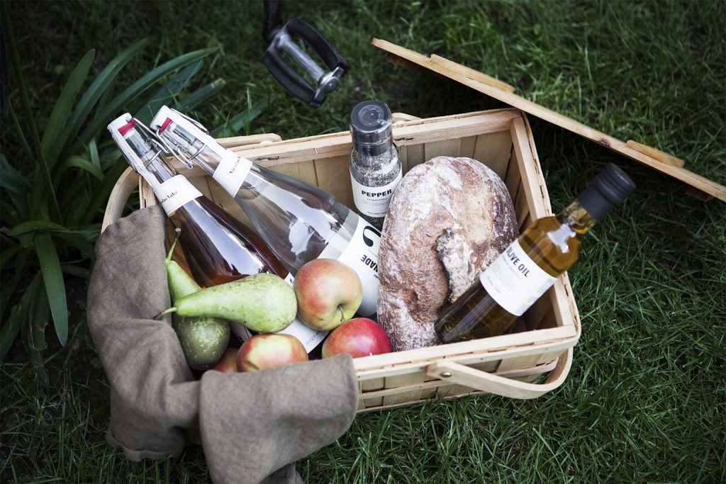 Picknick Korb mit Limonaden, Obst, Brot, Olivenöl und Salzmühle von Nicolas Vahé über Nordliebe