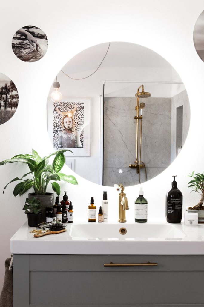 Badezimmer mit großem runden beleuchtetem Spiegel bei Miriam Jacks