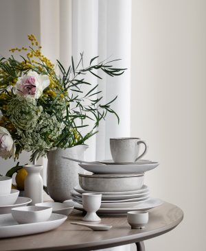 wunderschönes, handgefertigtes Nordic Sand Geschirr von Broste Copenhagen auf Tisch mit Blumen arrangiert - von Hej.Hem Interior