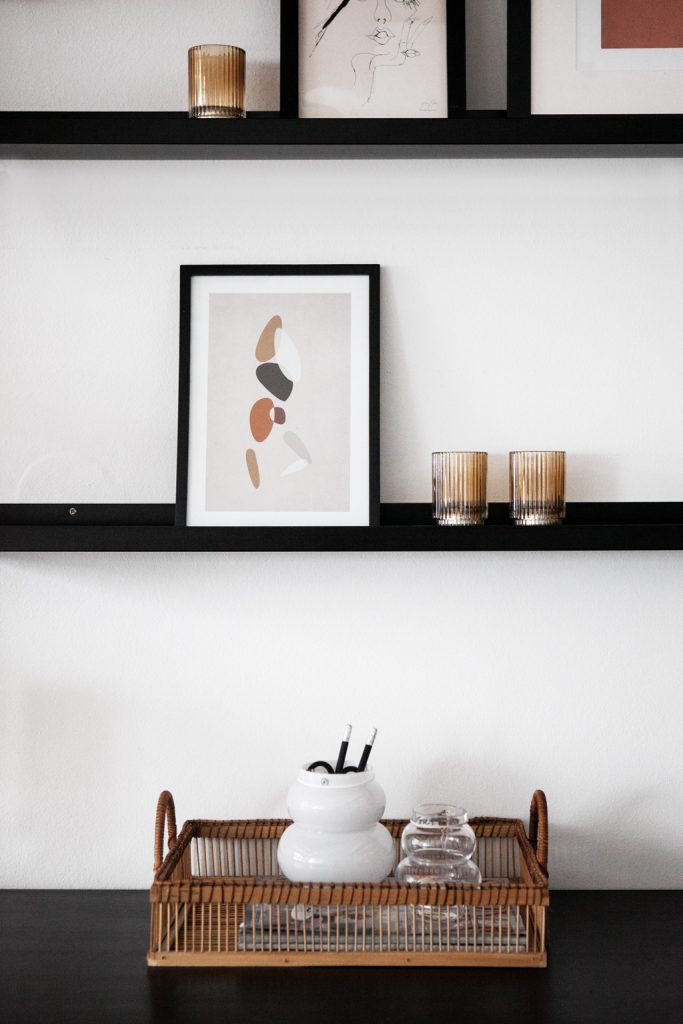 schwarze Bilderleiste, mit Bildern & braunen Teelichter, Rattantablett auf schwarzen Schreibtisch - von Hej.Hem Interior
