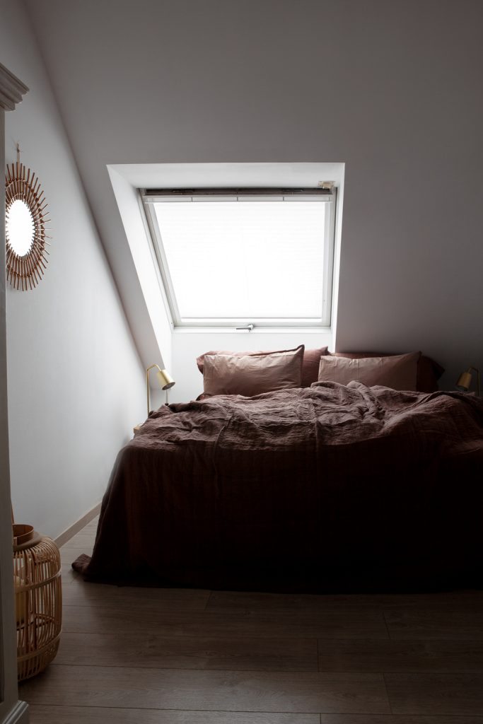 Schlafzimmer mit Bett unter Dachschräge , Bettwäsche in Beerentönen gehalten von byNord -von Hej.Hem Interior